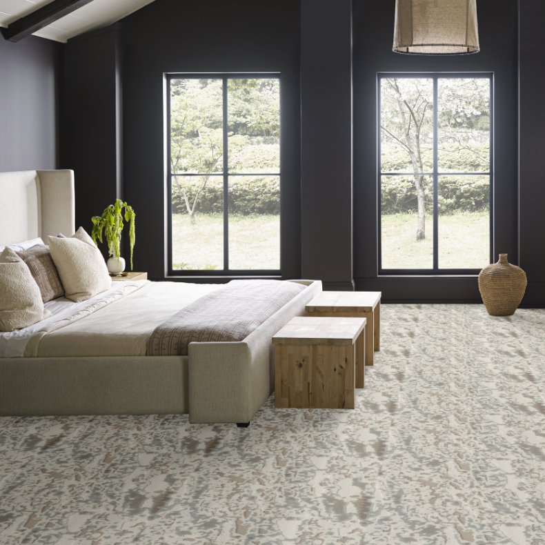 Bedroom with neat white bed and detailed carpet