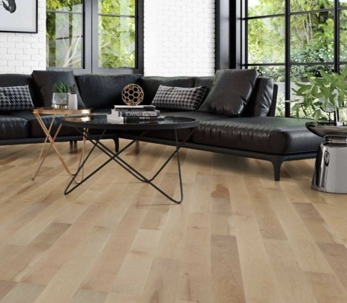 Black leather coach on light wood flooring