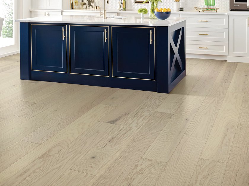 Navy blue kitchen island with light wood floors