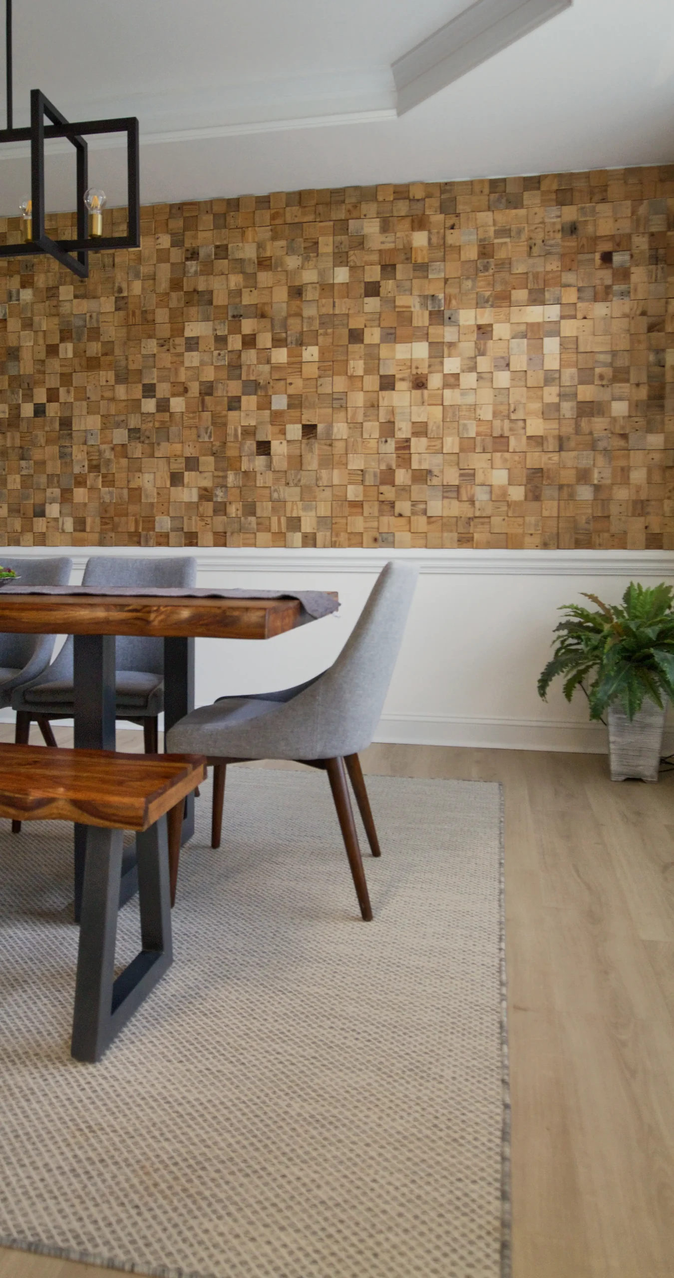 Cork style wall tile in dining room with wood floors and fuzzy rug